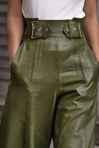 Green leather pants with a belt worn by a person.