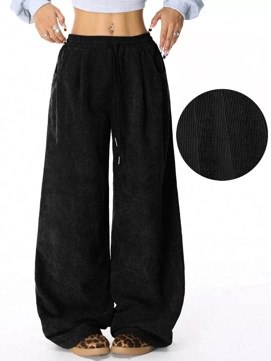 Black wide-leg pants with a close-up of the fabric texture on a white background