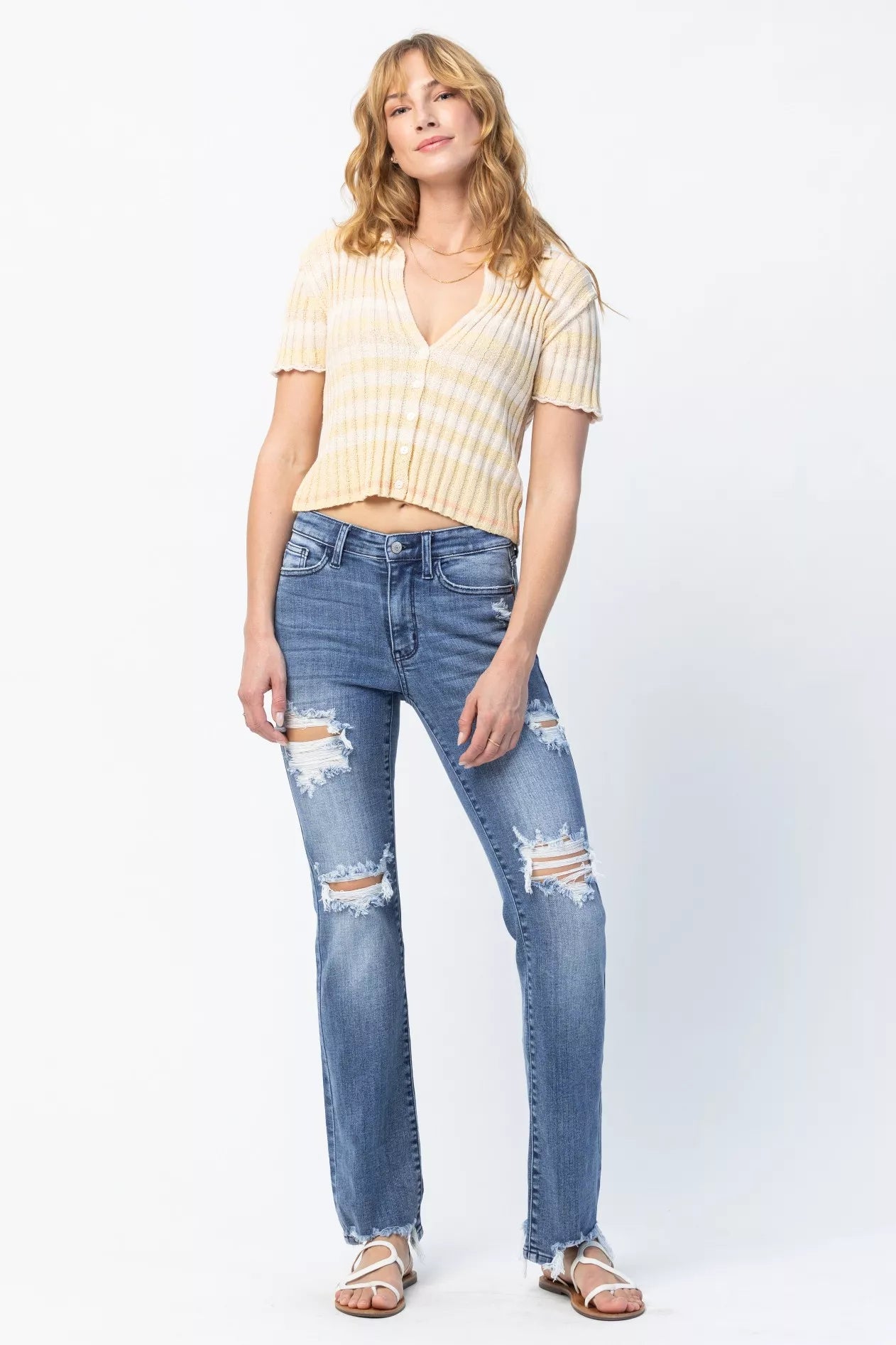Woman wearing a yellow striped shirt and blue jeans on a white background