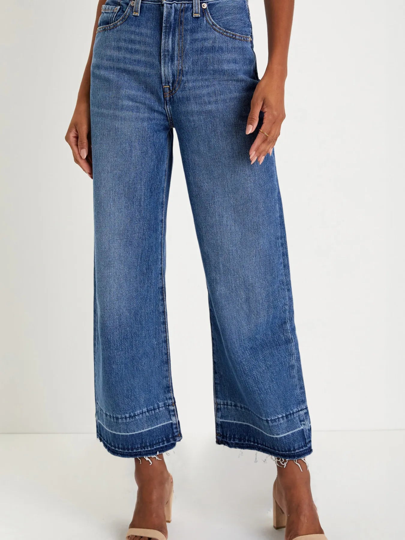 Blue jeans worn by a person on a white background