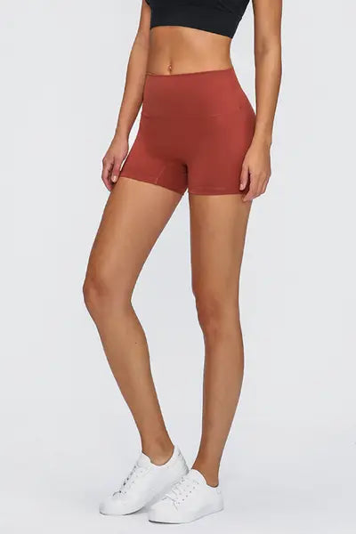 Person wearing red shorts and white sneakers on a plain background