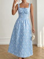 Woman wearing a blue floral dress indoors with a neutral background