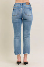 Blue jeans worn by a person on a beige background