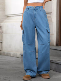 Person wearing blue cargo pants standing on a stone pavement.