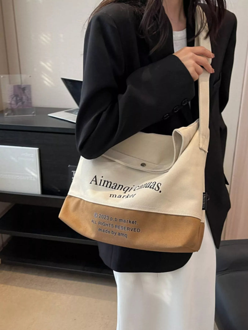 Person holding a beige and brown tote bag with text