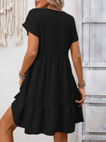 Woman wearing a black dress against a light wooden panel background