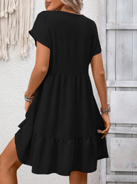 Woman wearing a black dress against a light wooden panel background