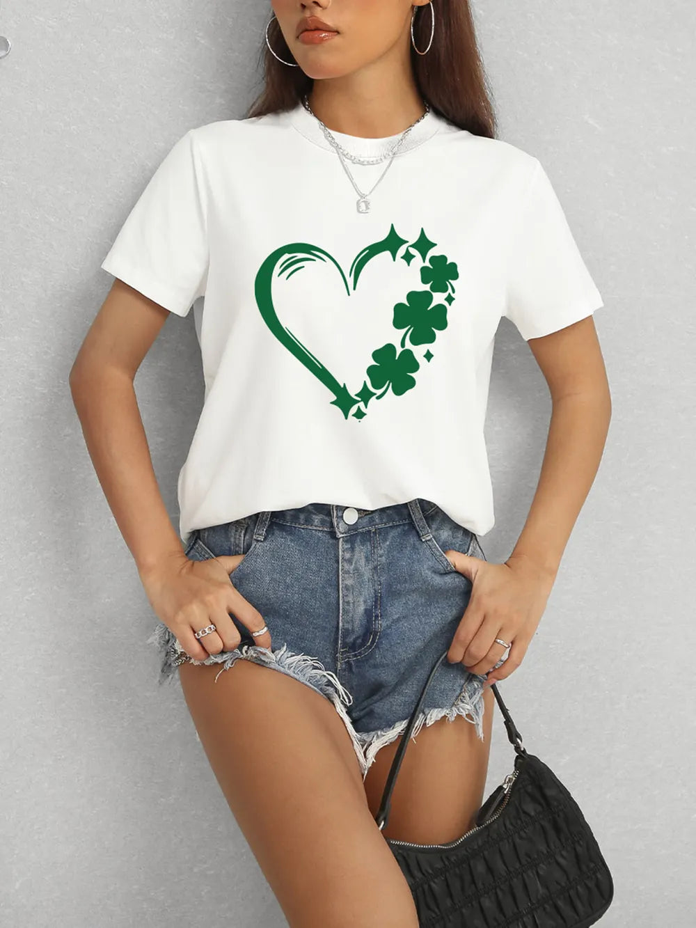 Person wearing a white t-shirt with a green shamrock design on a gray background