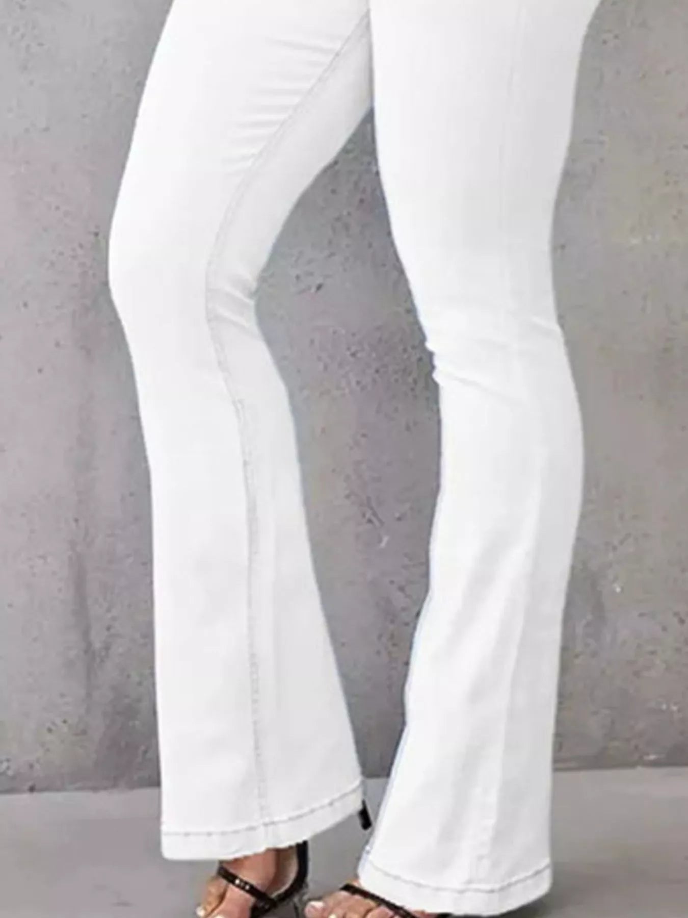 White flared jeans on a plain background