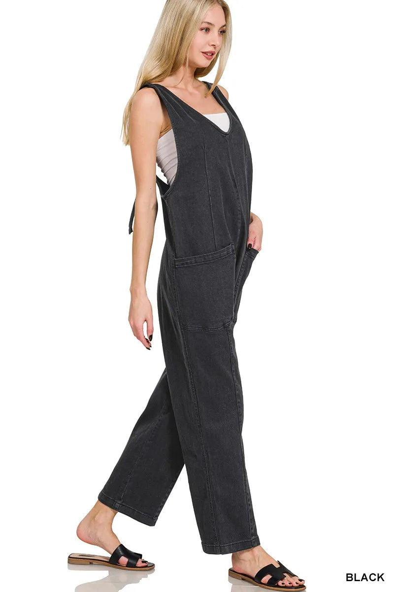 Woman wearing a black denim jumpsuit on a white background