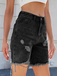 Black distressed denim shorts worn by a person with a neutral background