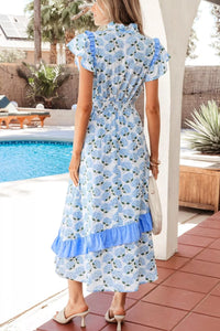 Woman wearing a blue floral dress by a poolside