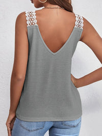 Gray tank top with lace straps worn by a person on a white background