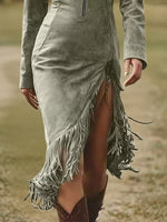 Person wearing a green suede dress with fringe details in a natural setting
