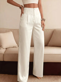 Person wearing white pants standing in a room with a beige couch.