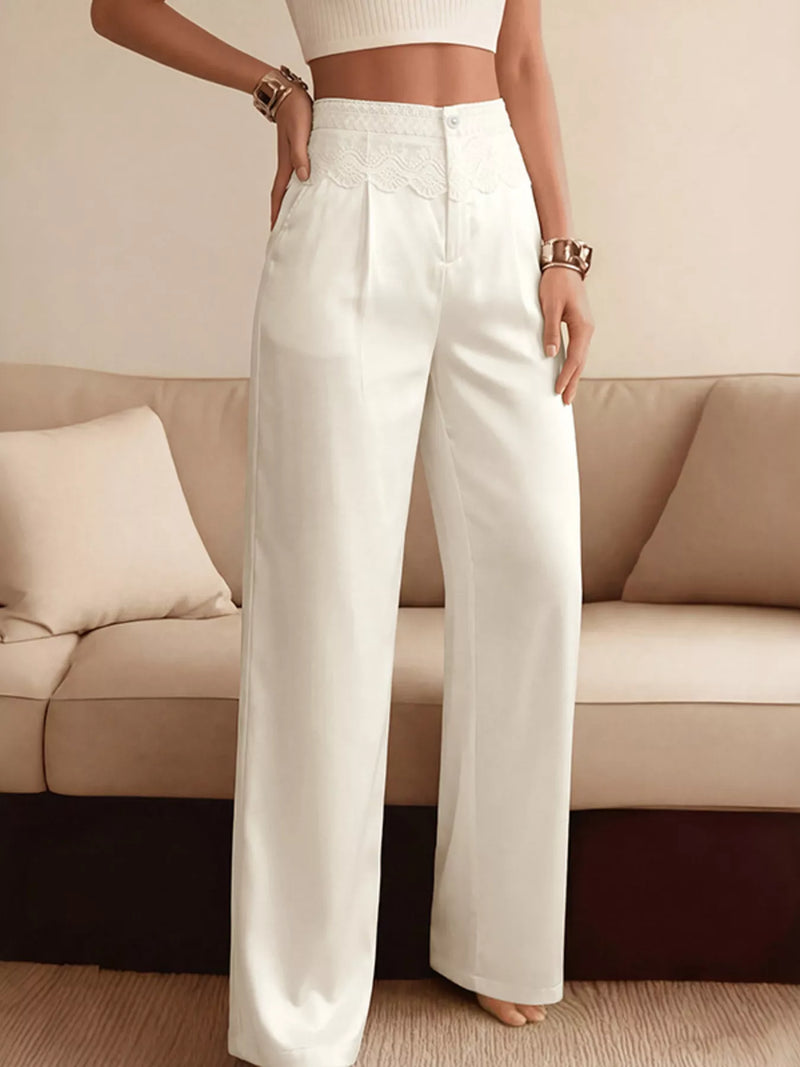 Person wearing white pants standing in a room with a beige couch.