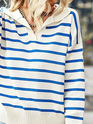 Close-up of a person wearing a white sweater with blue horizontal stripes.