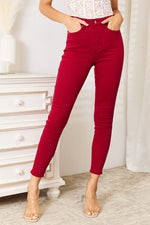 Person wearing red pants standing in a room with a white dresser.