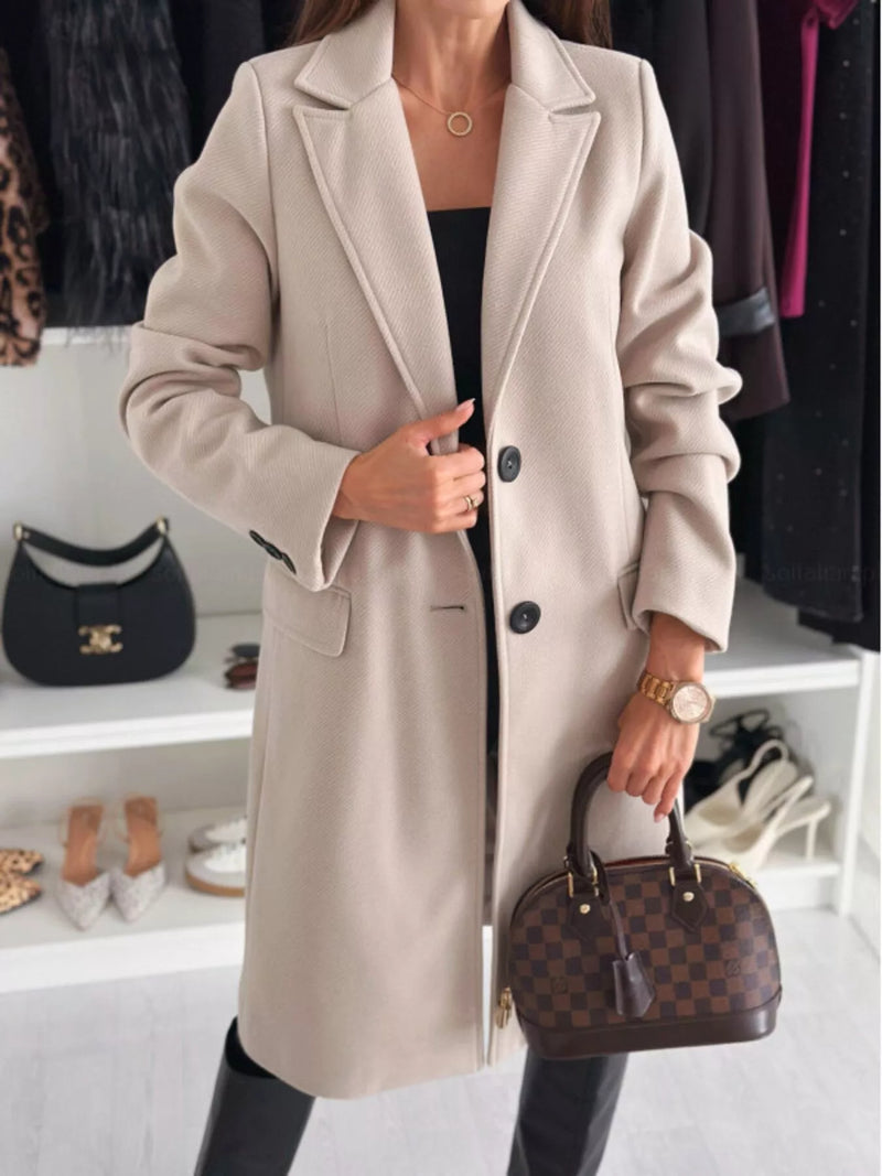 Person wearing a beige coat holding a brown handbag in a clothing store setting