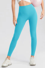 Person wearing turquoise leggings on a plain background