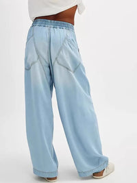 Light blue denim pants worn by a person on a white background