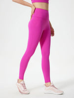 Person wearing bright pink leggings and a matching top on a white background