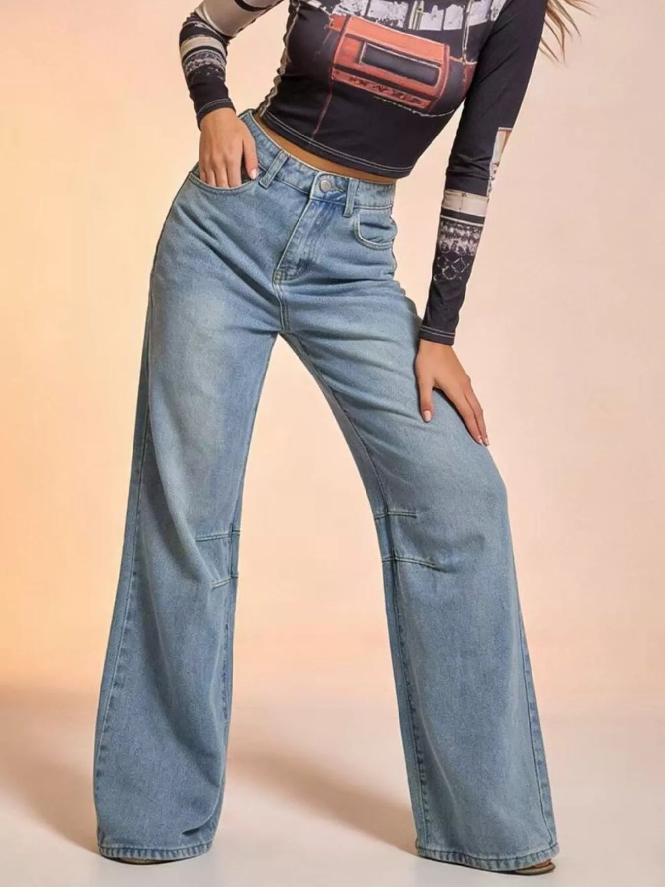 Person wearing light blue jeans on a beige background