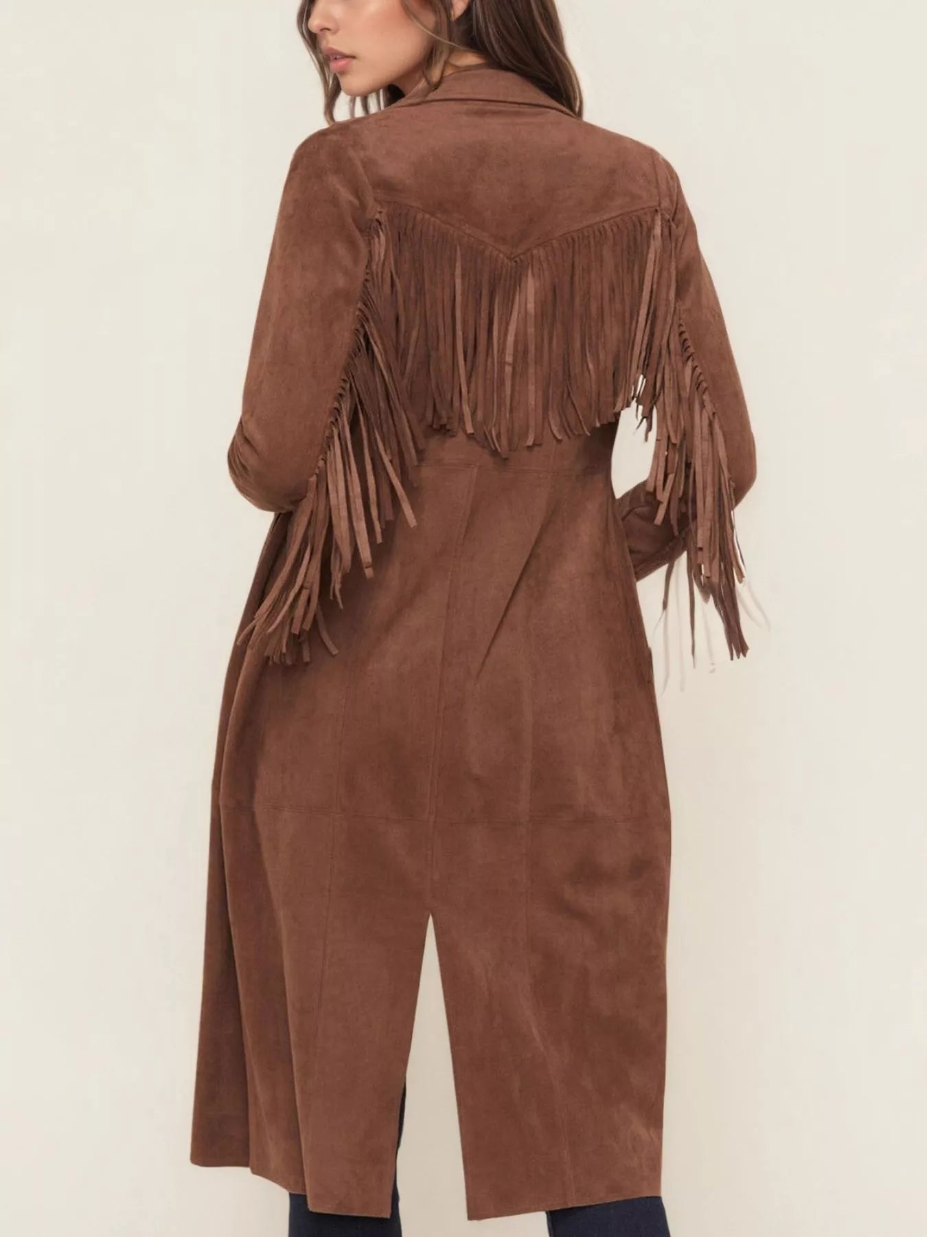 Brown suede coat with fringe details on a plain background