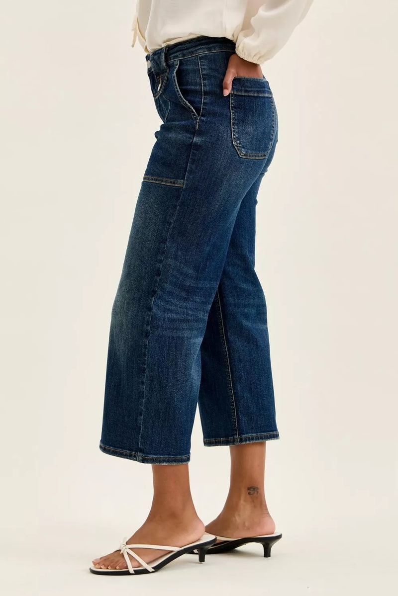 Person wearing blue jeans on a plain background