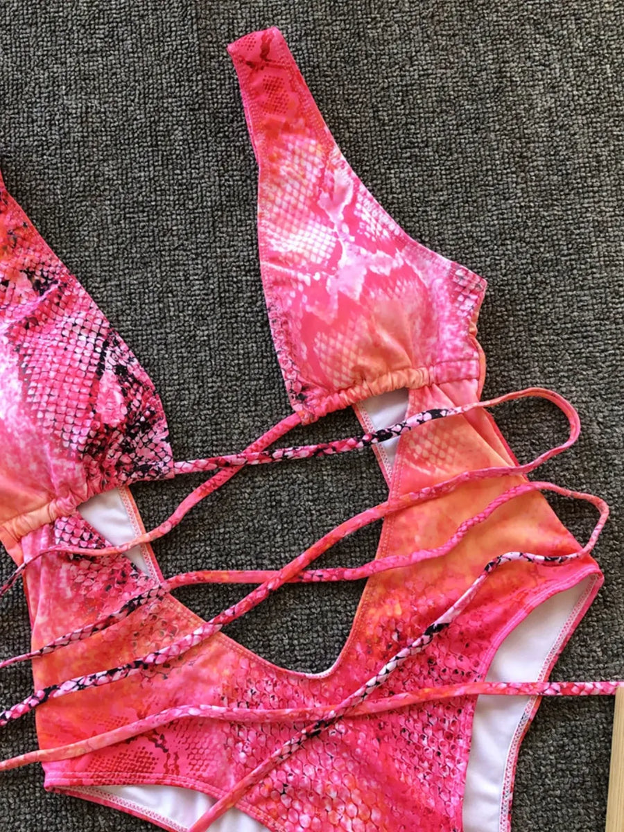 Pink and orange patterned bikini set on a textured surface