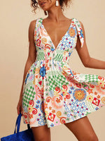 Woman wearing a colorful patterned dress against a beige background