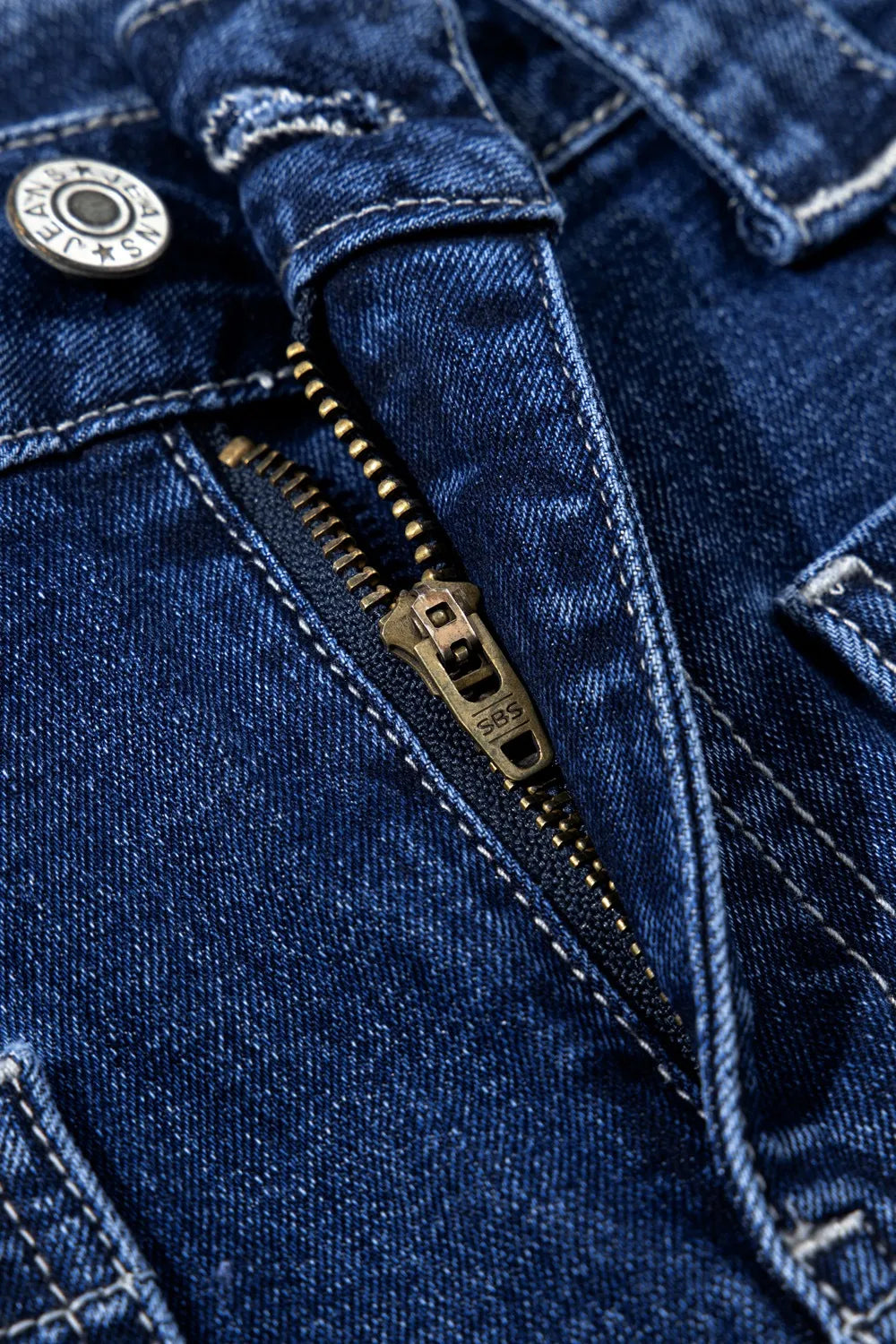 Close-up of a blue denim jacket with a zipper and button