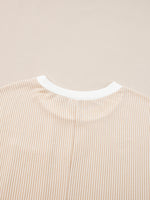 Close-up of a beige and white striped shirt collar on a beige background