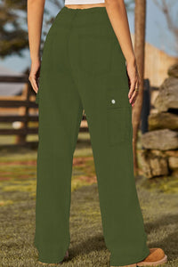 Person wearing green cargo pants in an outdoor setting with a blurred background