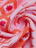 Close-up of pink fabric with red and white geometric patterns