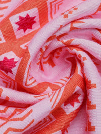 Close-up of pink fabric with red and white geometric patterns