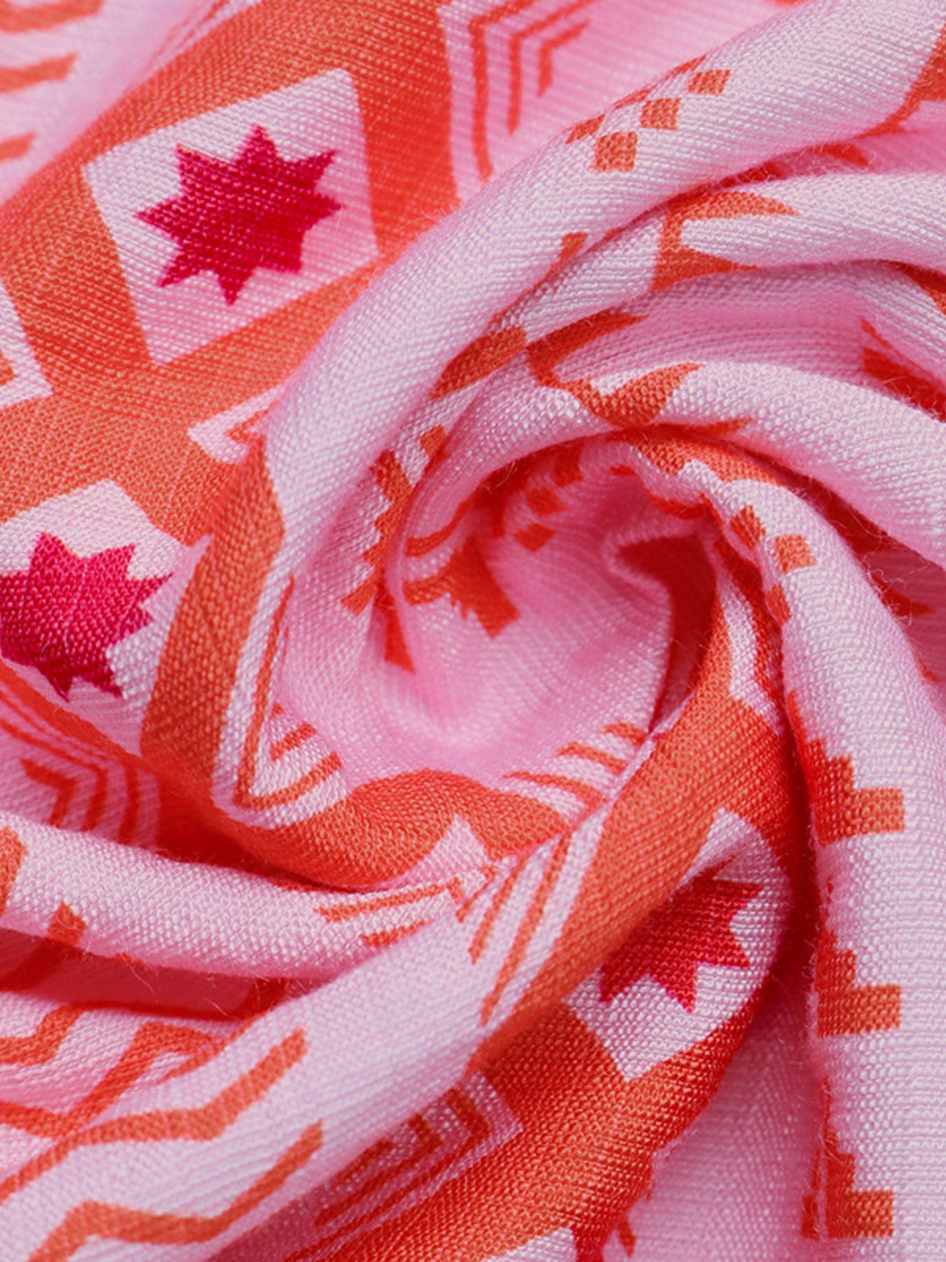 Close-up of pink fabric with red and white geometric patterns