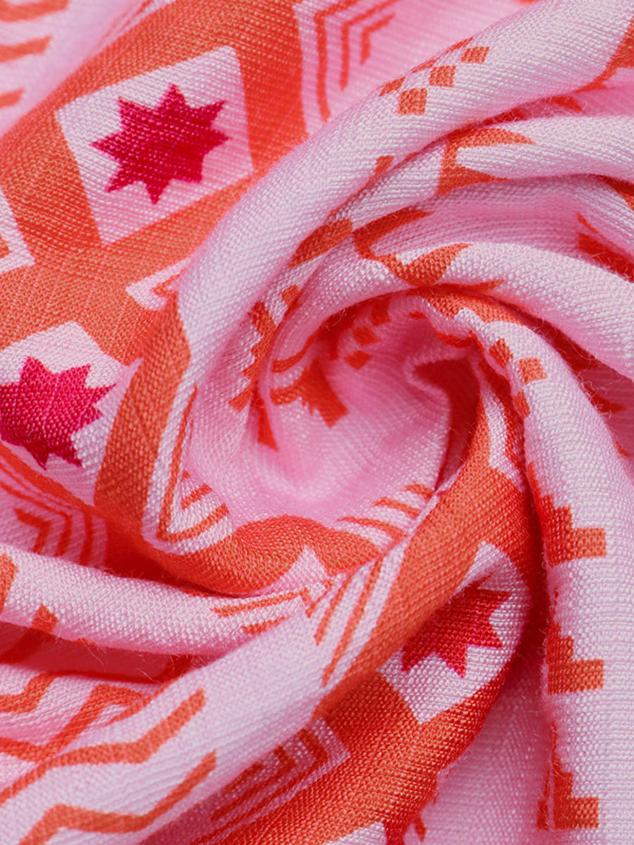 Close-up of pink fabric with red and white geometric patterns