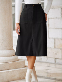 Person wearing a black skirt and white top standing on stone steps.