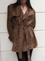 Brown suede trench coat worn by a person against a white background