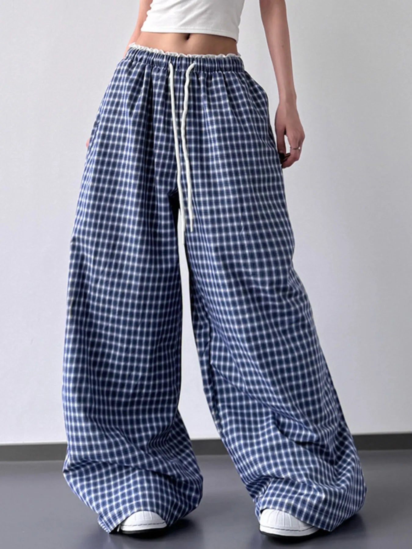 Blue and white checkered wide-leg pants worn by a person on a plain background