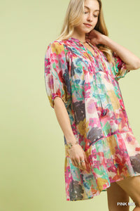 Woman wearing a colorful floral dress against a light green background