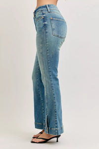 Blue jeans worn by a person on a plain background