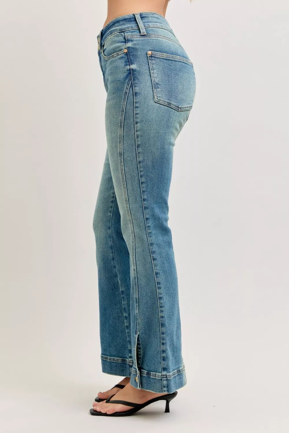 Blue jeans worn by a person on a plain background