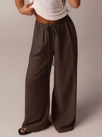 Brown wide-leg pants worn by a person on a plain background