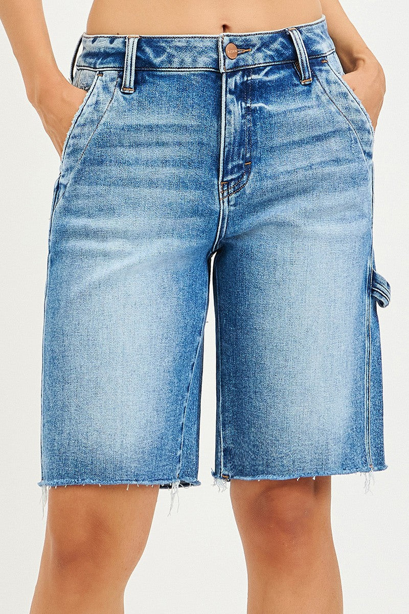 Blue denim shorts worn by a person on a white background