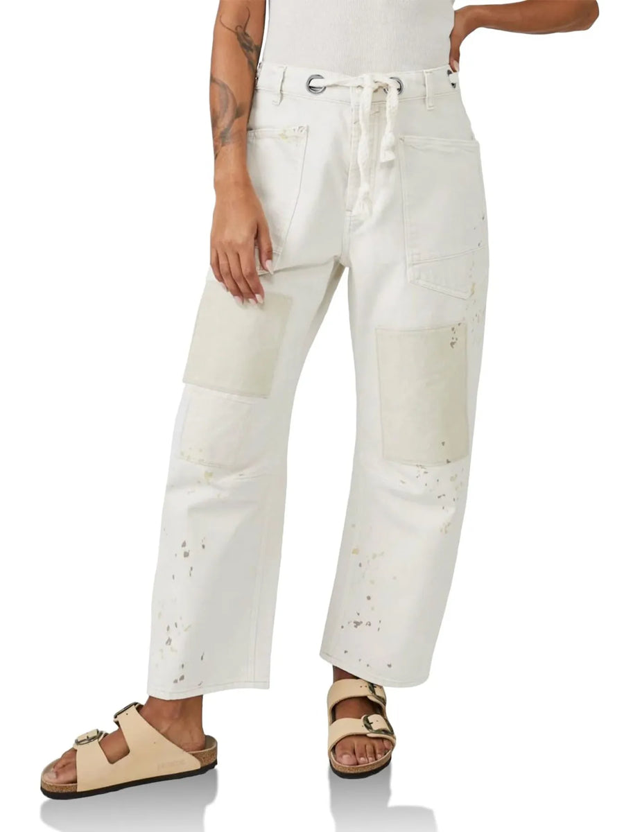 Person wearing white distressed jeans on a white background