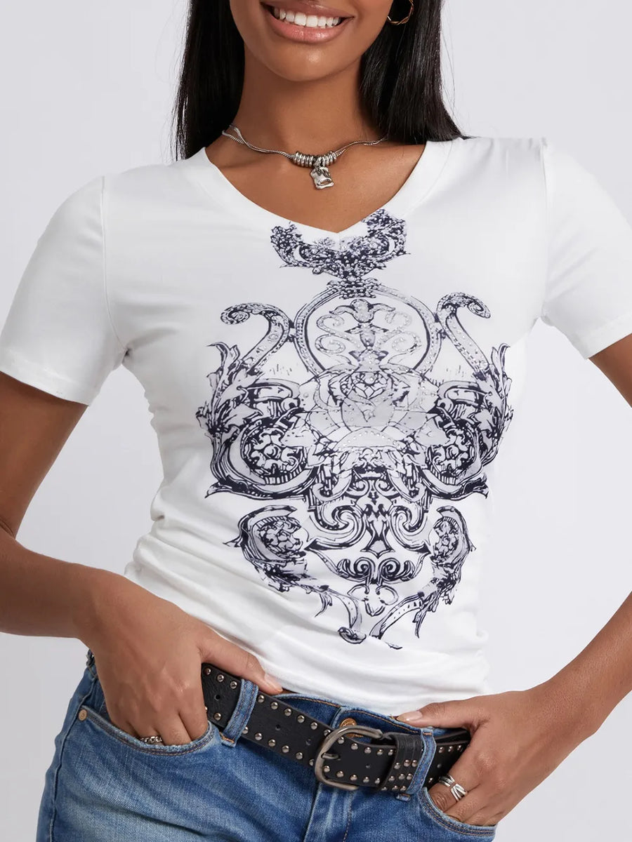 Person wearing a white t-shirt with black intricate design on a plain background