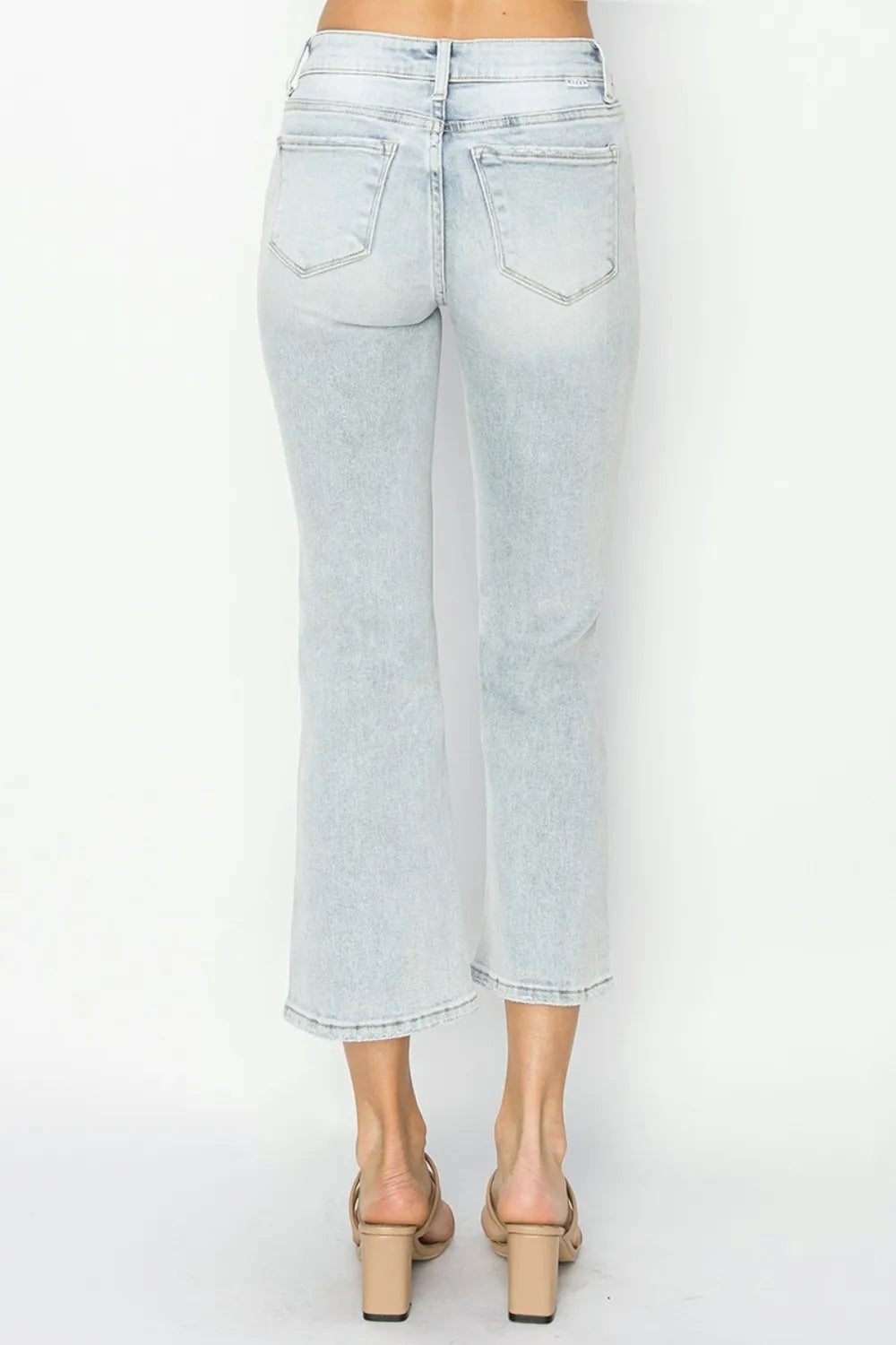 Light blue jeans worn by a person on a white background
