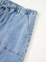 Close-up of light blue denim shorts on a white background